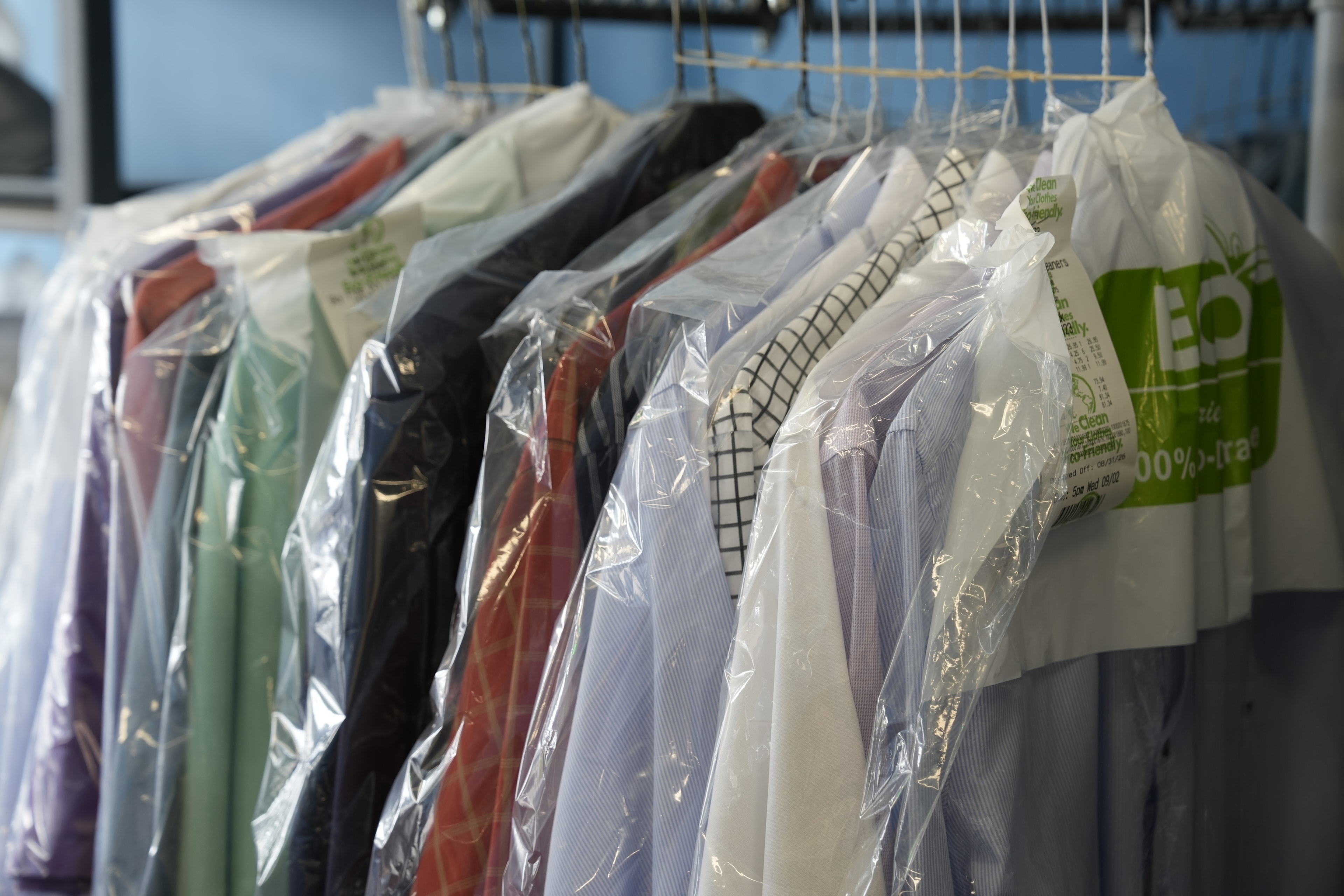 Freshly cleaned garments protected in clear covers at Sky Cleaners